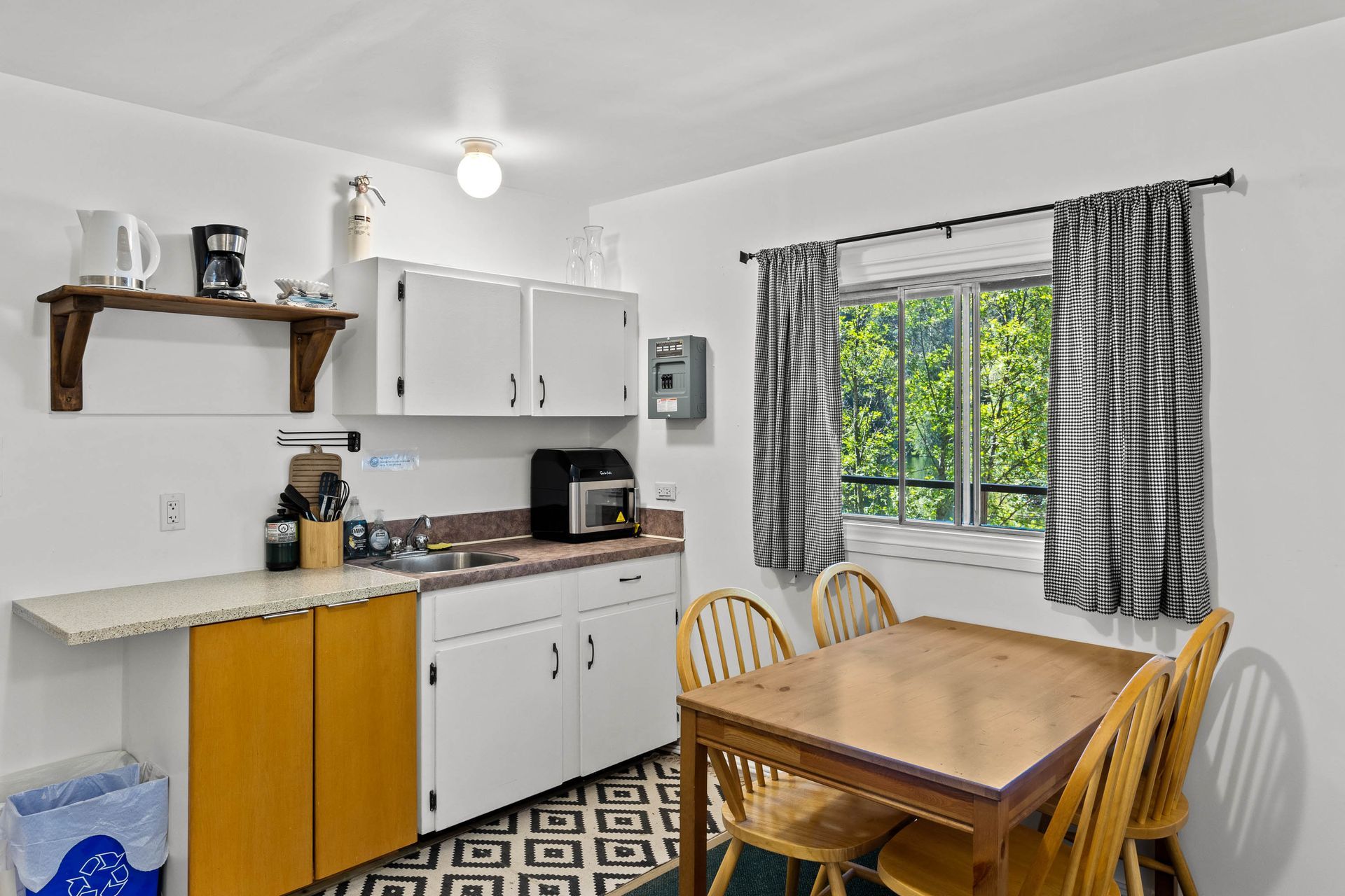 A kitchen with a table and chairs and a window.