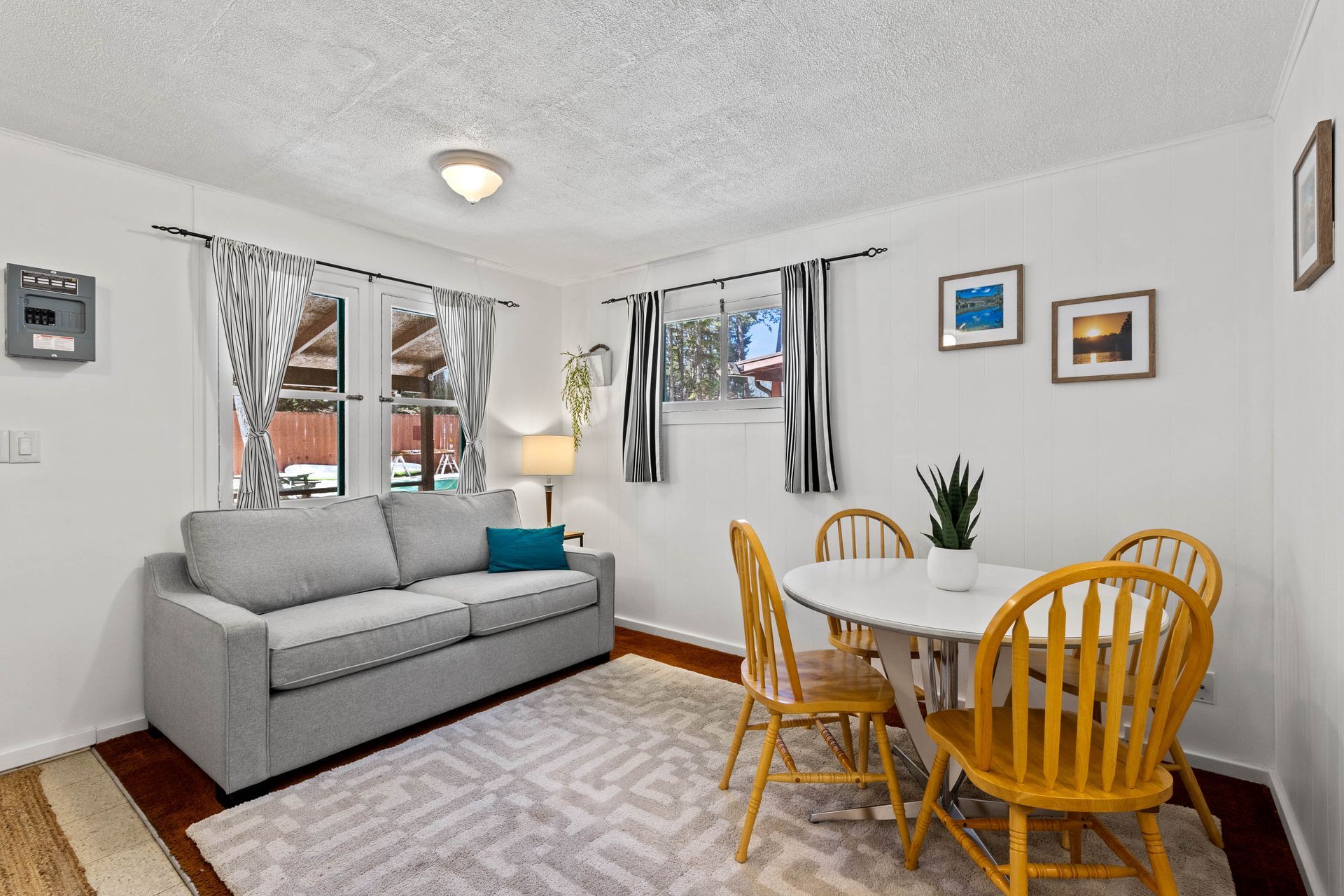 A living room with a couch , table and chairs.
