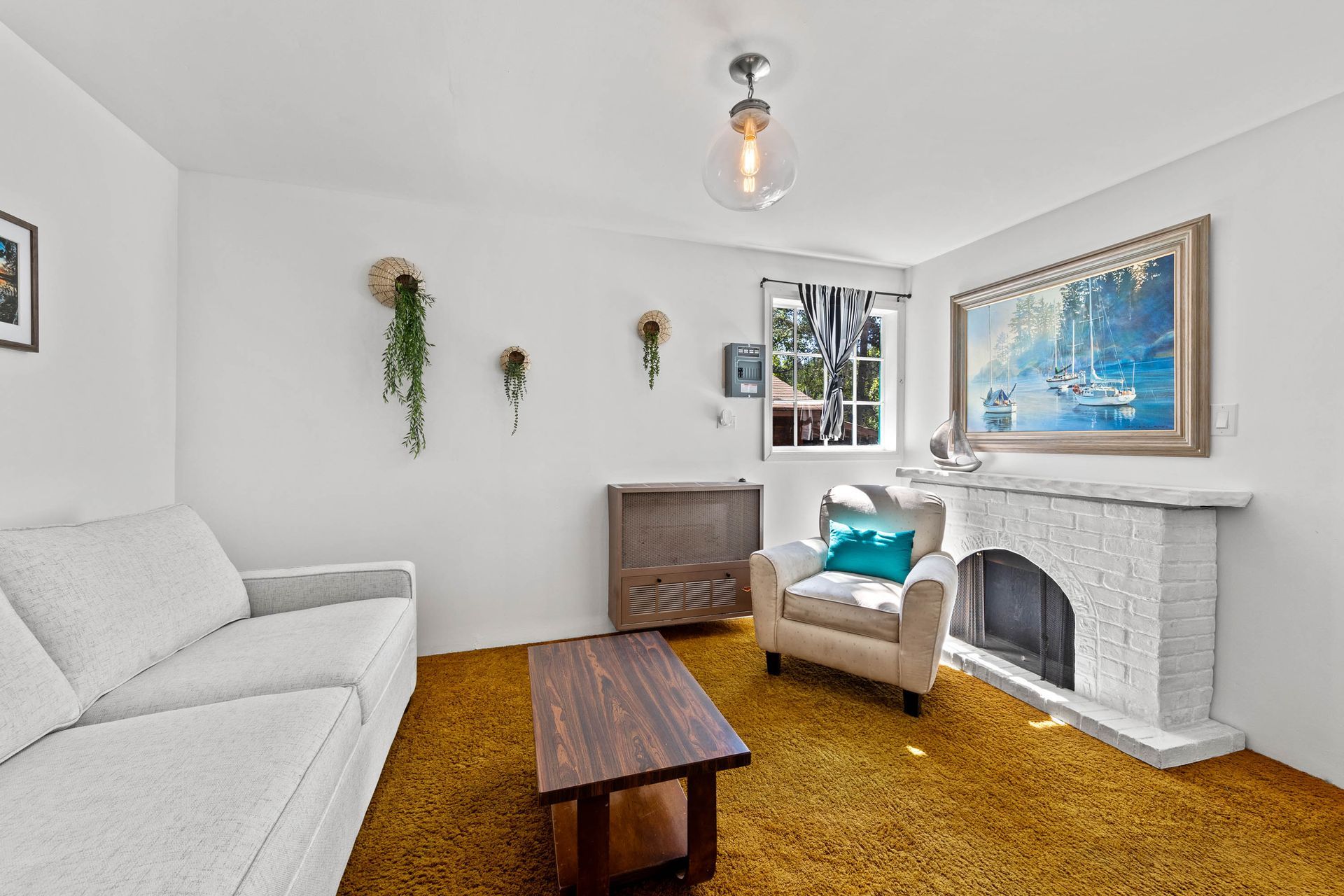 A living room with a couch , chair , coffee table and fireplace.