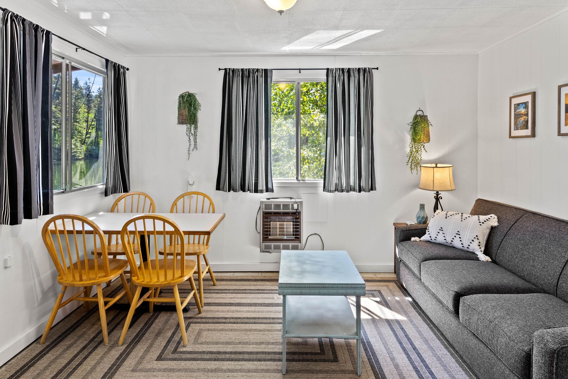 A living room with a couch , table and chairs.