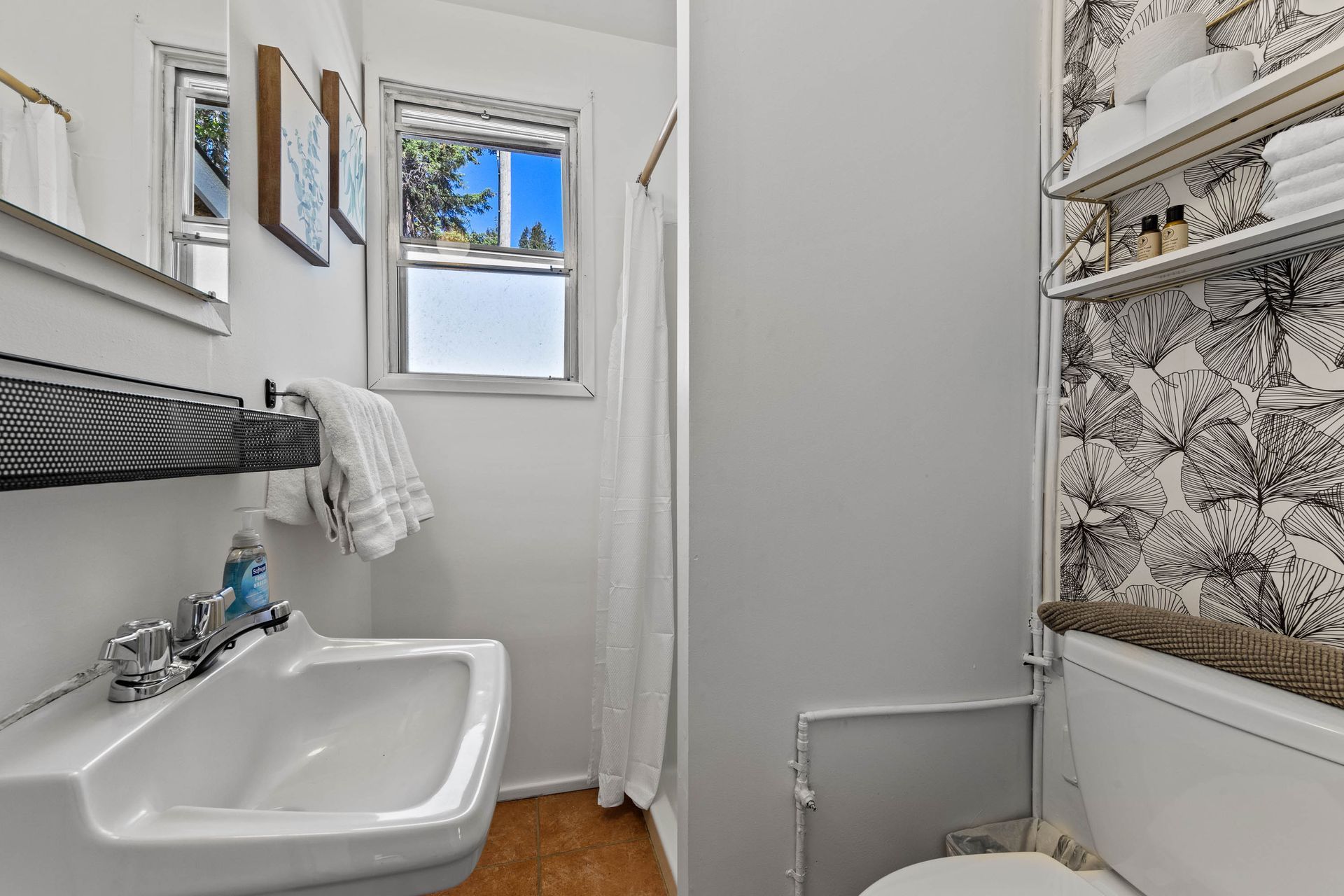 A bathroom with a sink , toilet and shower.