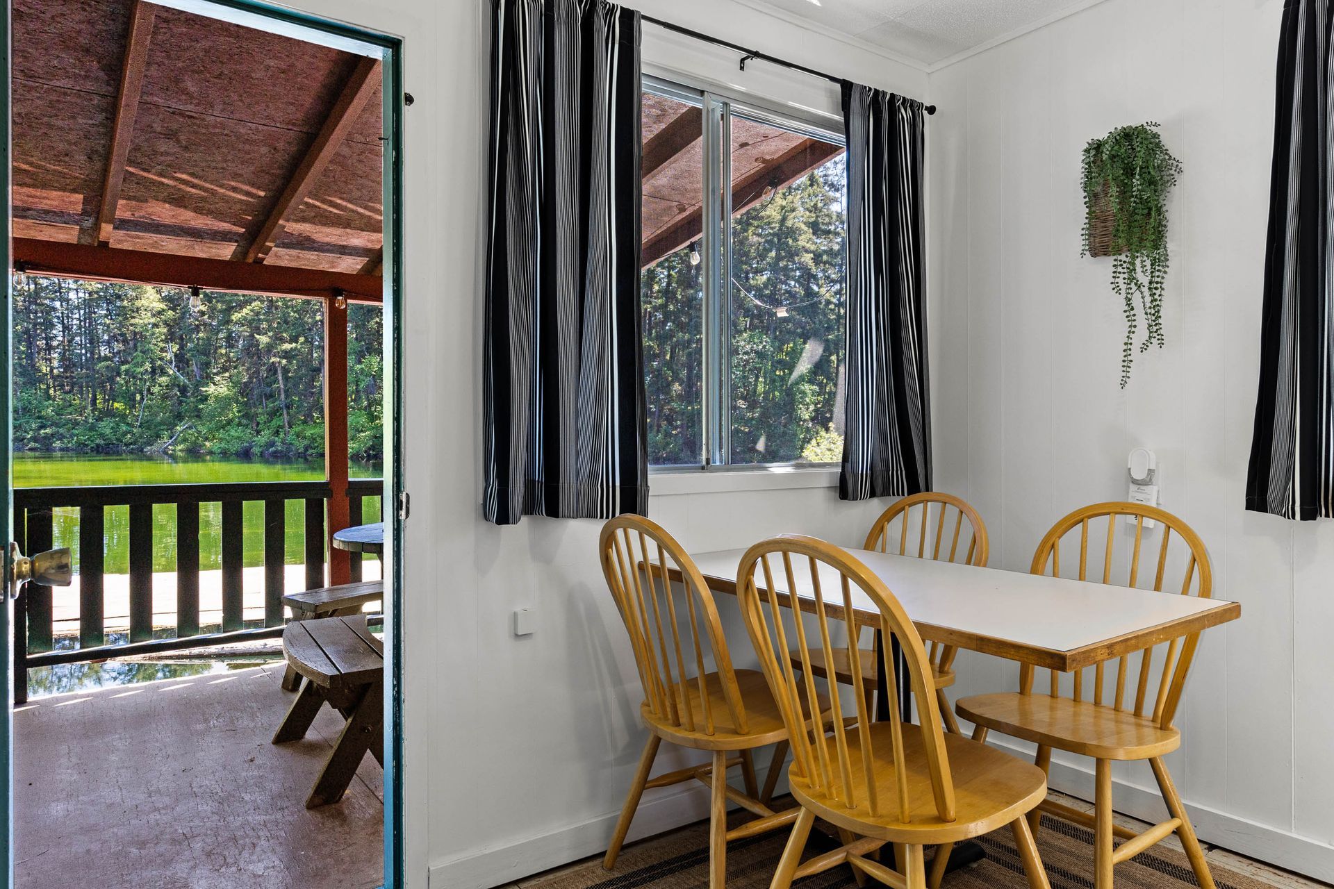 A dining room with a table and chairs and a balcony.