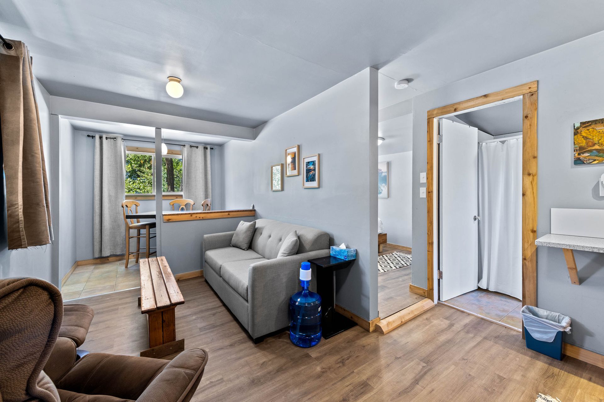 A living room with a couch , chair , table and a water bottle.