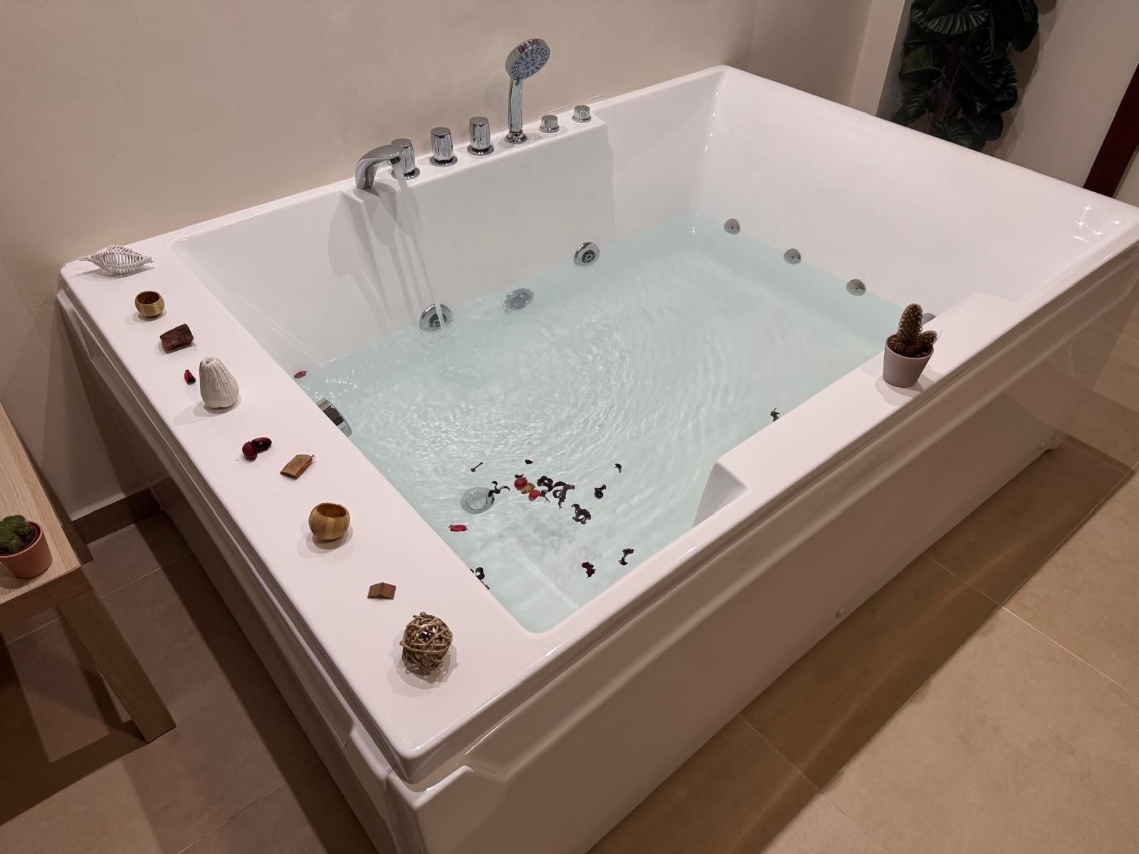 Una grande vasca da bagno piena d'acqua e pietre in un bagno.