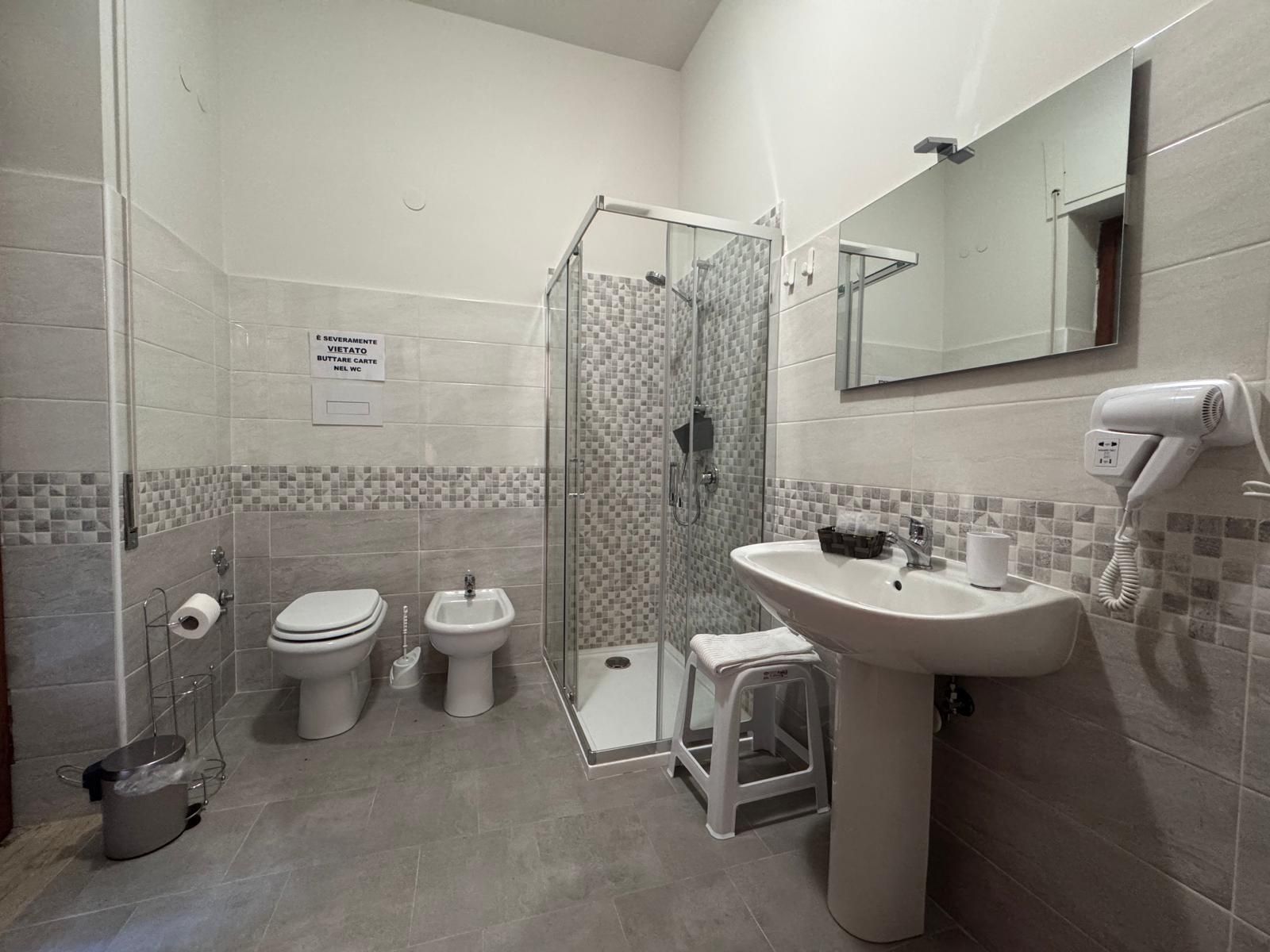 Un bagno con lavandino, wc, bidet e doccia.