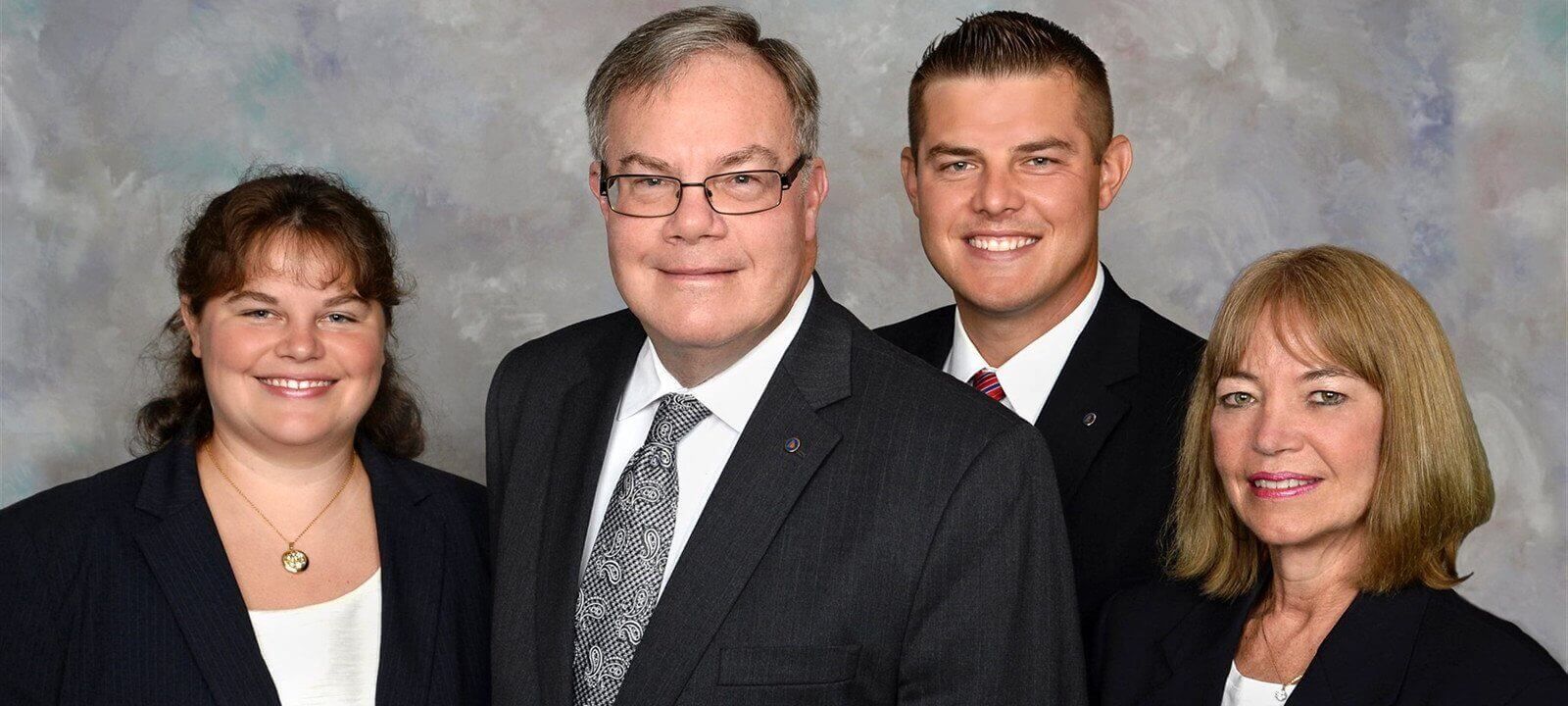 A group of people in suits and ties are posing for a picture.