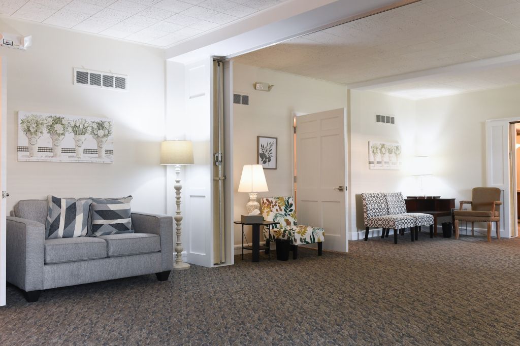 A living room with a couch and chairs and a sign that says love