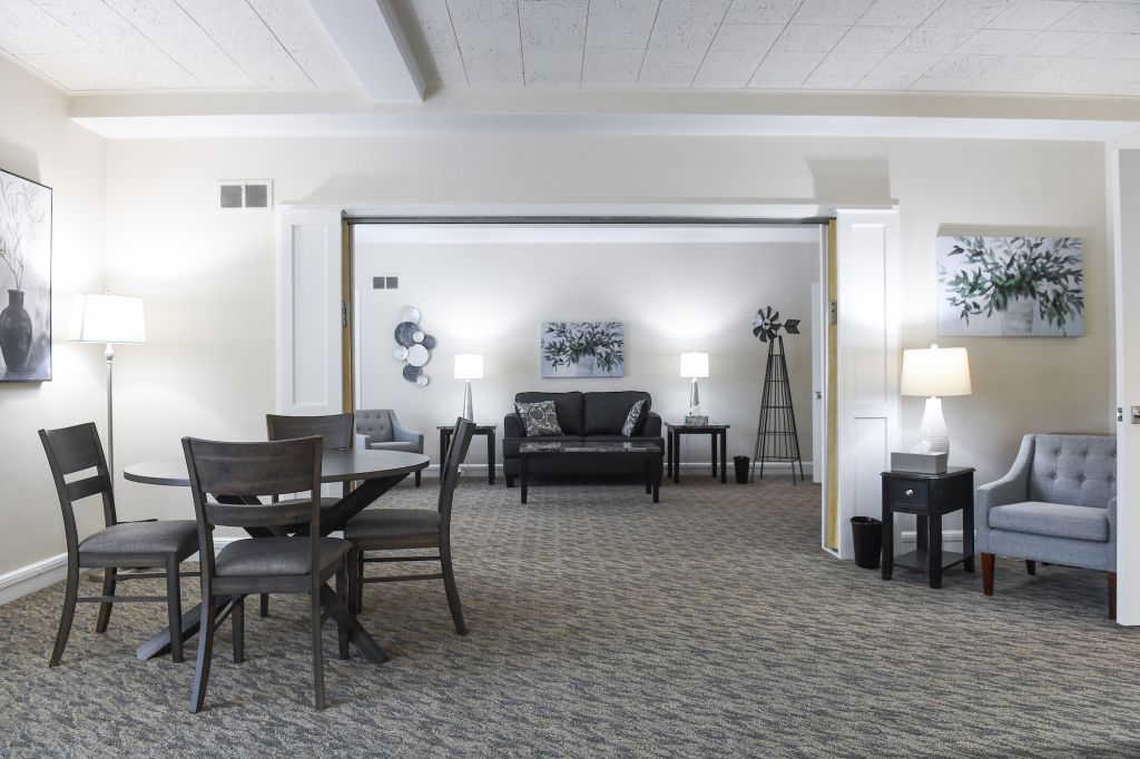 A living room with a table and chairs and a couch.