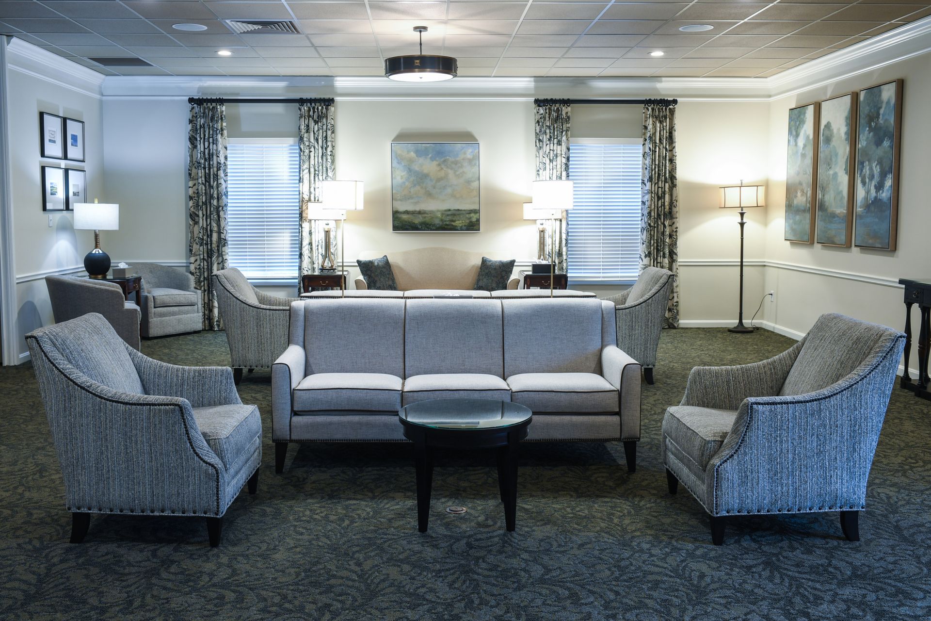 A living room with a couch , chairs , and a table.