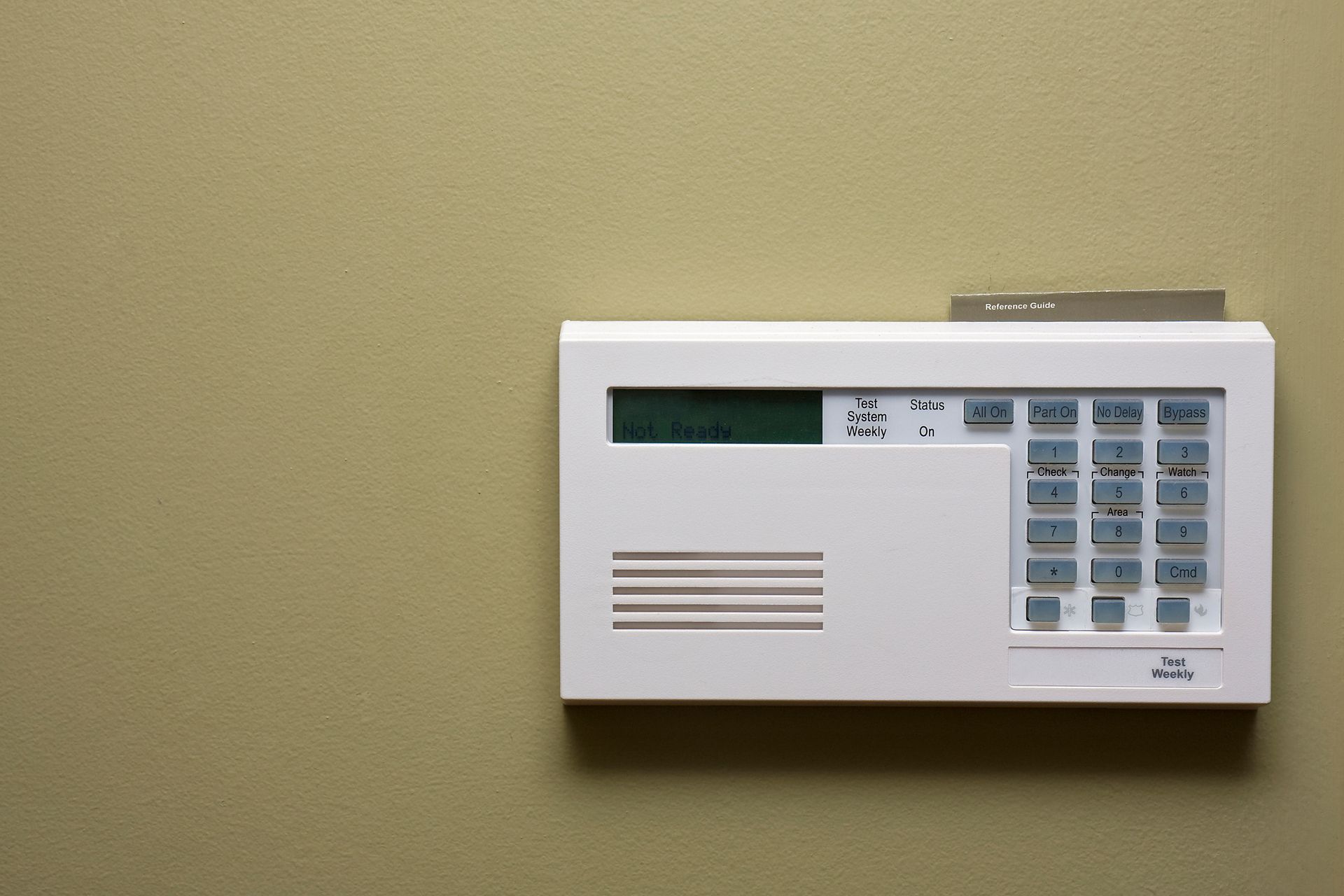 Wall-mounted alarm system with keypad and digital display for home security.