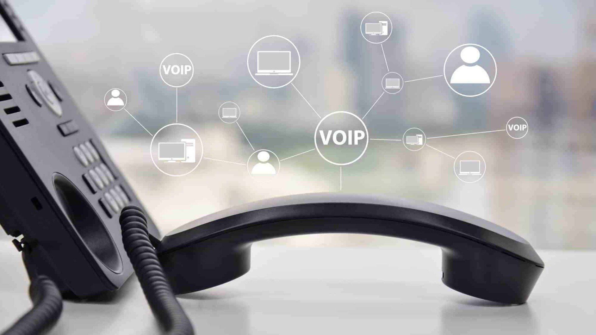 Business phone on a desk with communication icons on top.