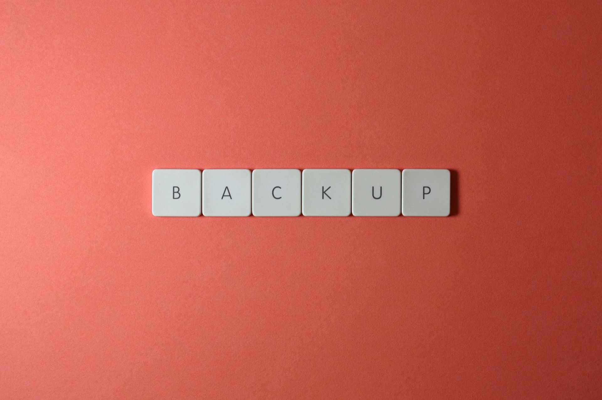 The word backup is written in scrabble tiles on a red background.