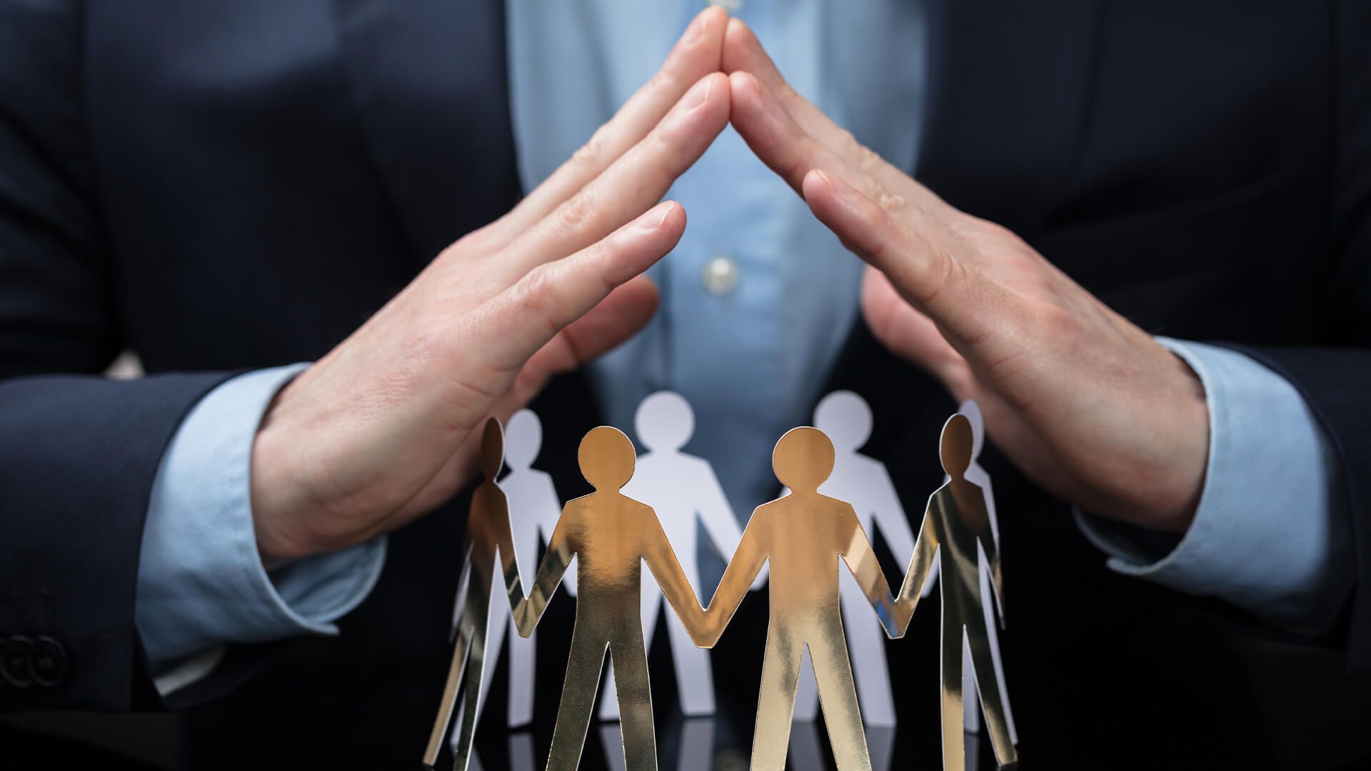 hands covering paper cutouts represents professional liability Insurance