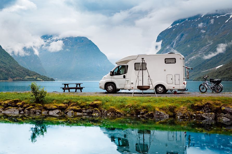 RV and motorcycle overlooking a lake and mountains