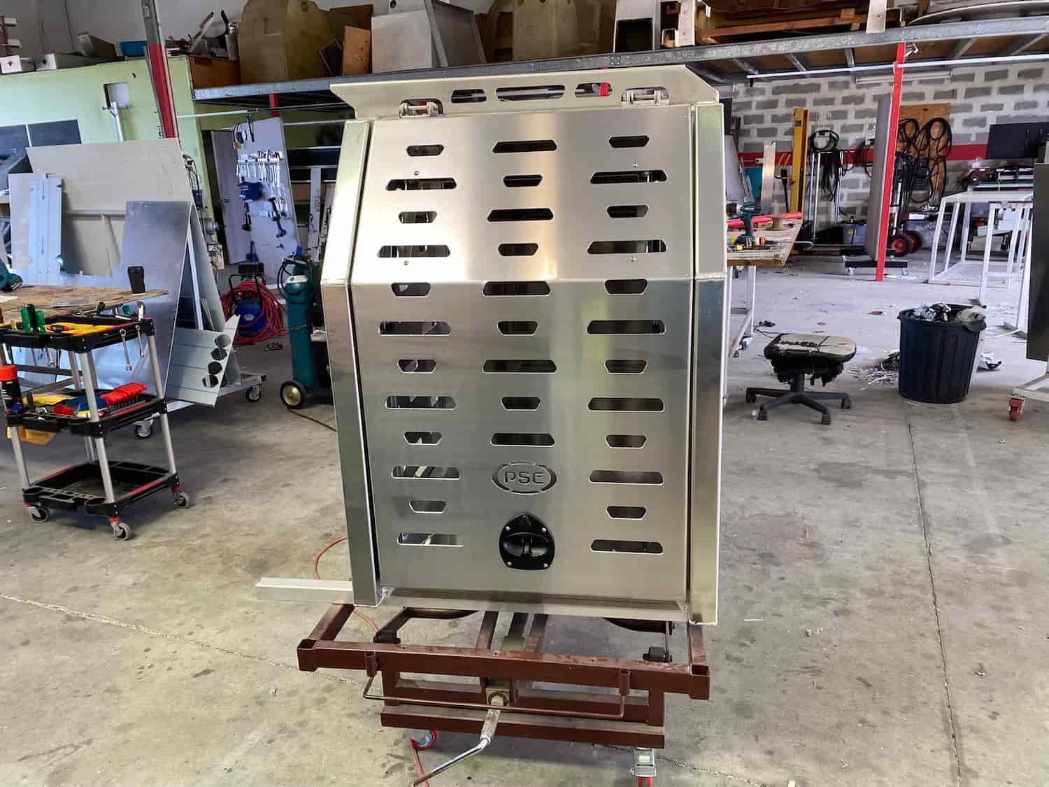 A Large Stainless Steel Box is Sitting on Top of a Wooden Table in a Workshop — PSE Stainless Steel Fabrications In Manunda, QLD
