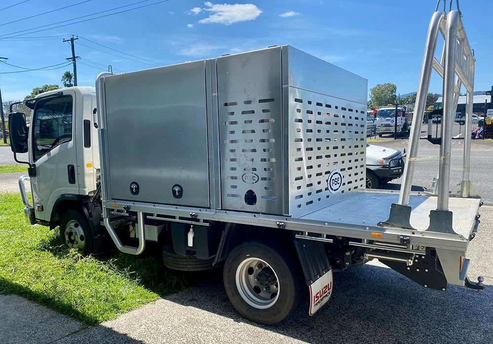 A Silver Truck with A Box on The Back Is Parked on The Side of The Road — PSE Stainless Steel Fabrications in Manunda, QLD