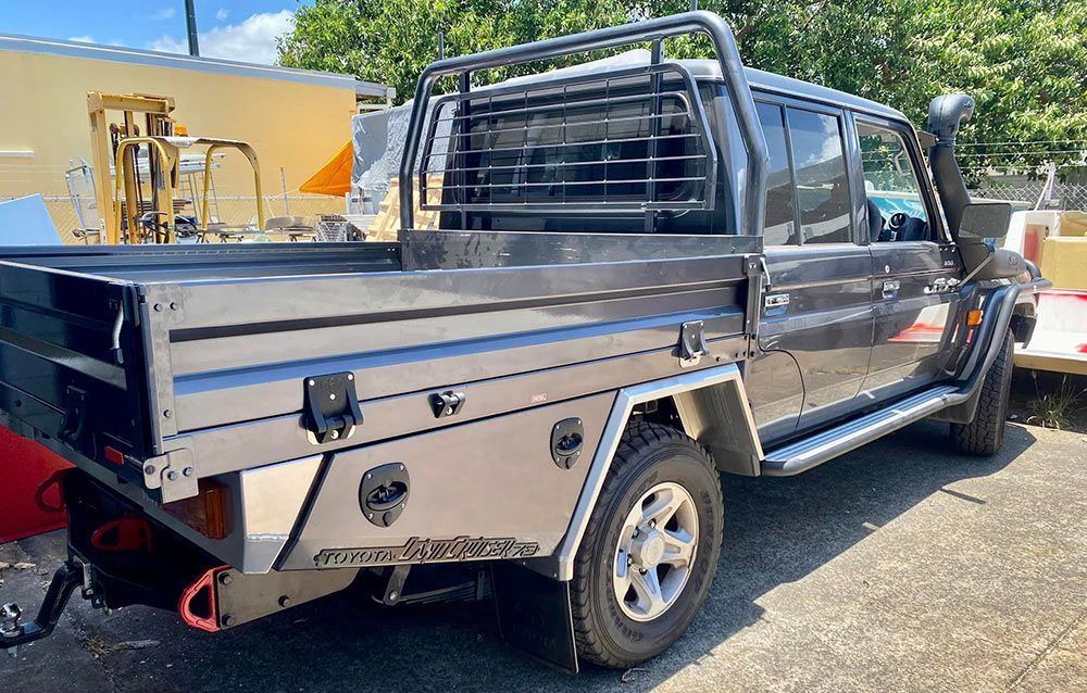 A truck with a tray bed is parked on the side of the road  — PSE Stainless Steel Fabrications in Manunda, QLD