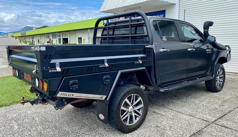 A Black Truck with A Tray on The Back Is Parked in Front of A Building — PSE Stainless Steel Fabrications in Manunda, QLD