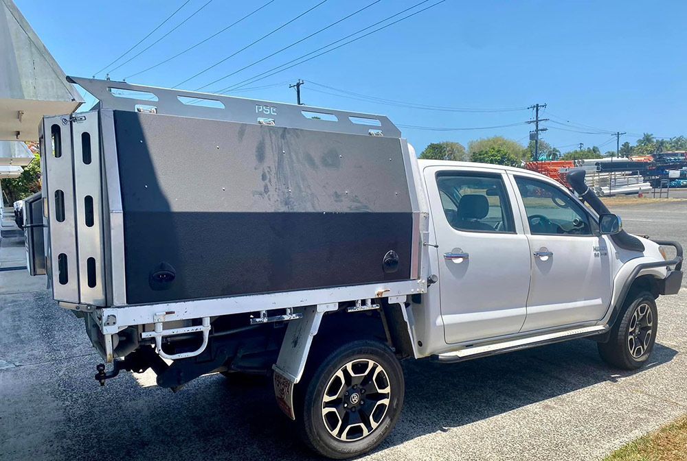 A white truck with a canopy is parked on the side of the road  — PSE Stainless Steel Fabrications in Manunda, QLD