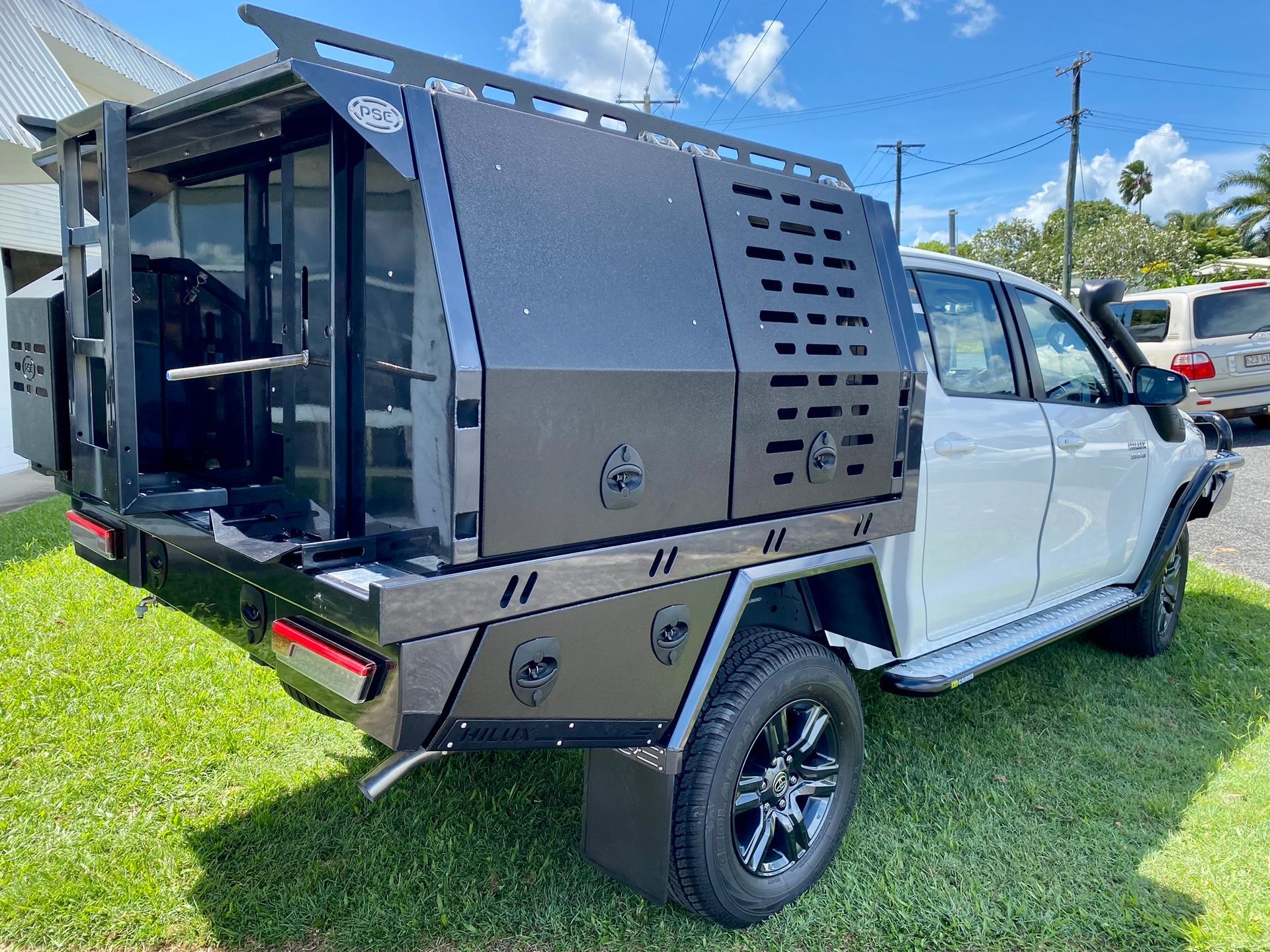 A white truck with a black canopy is parked in the grass  — PSE Stainless Steel Fabrications in Manunda, QLD