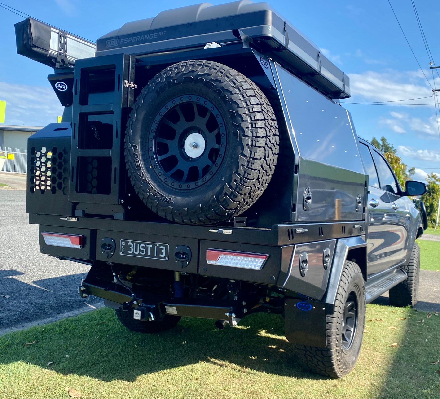 A black truck with a spare tire on the back is parked on the grass  — PSE Stainless Steel Fabrications in Manunda, QLD