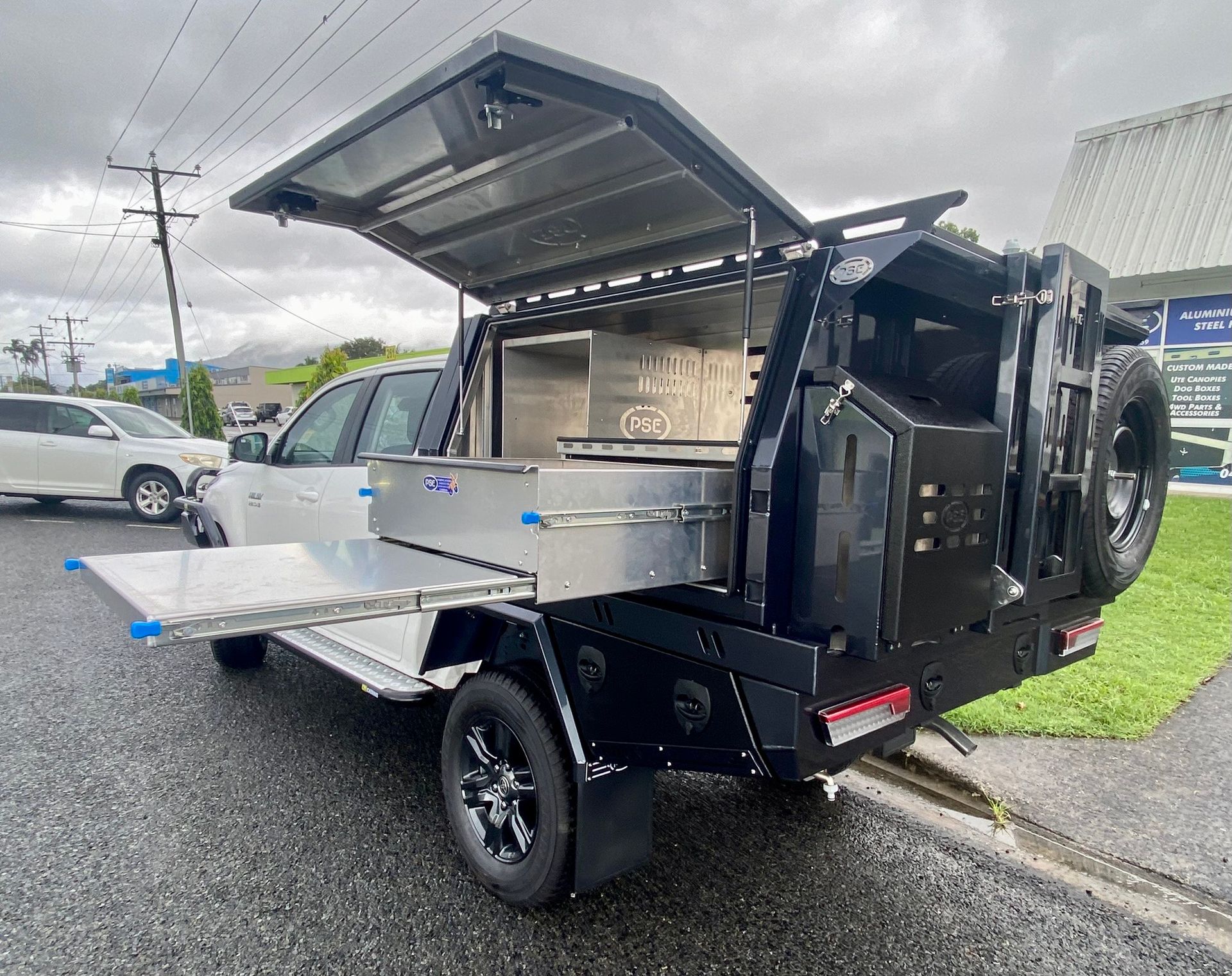A White Truck with A Black Bed Is Parked in The Grass — PSE Stainless Steel Fabrications in Manunda, QLD