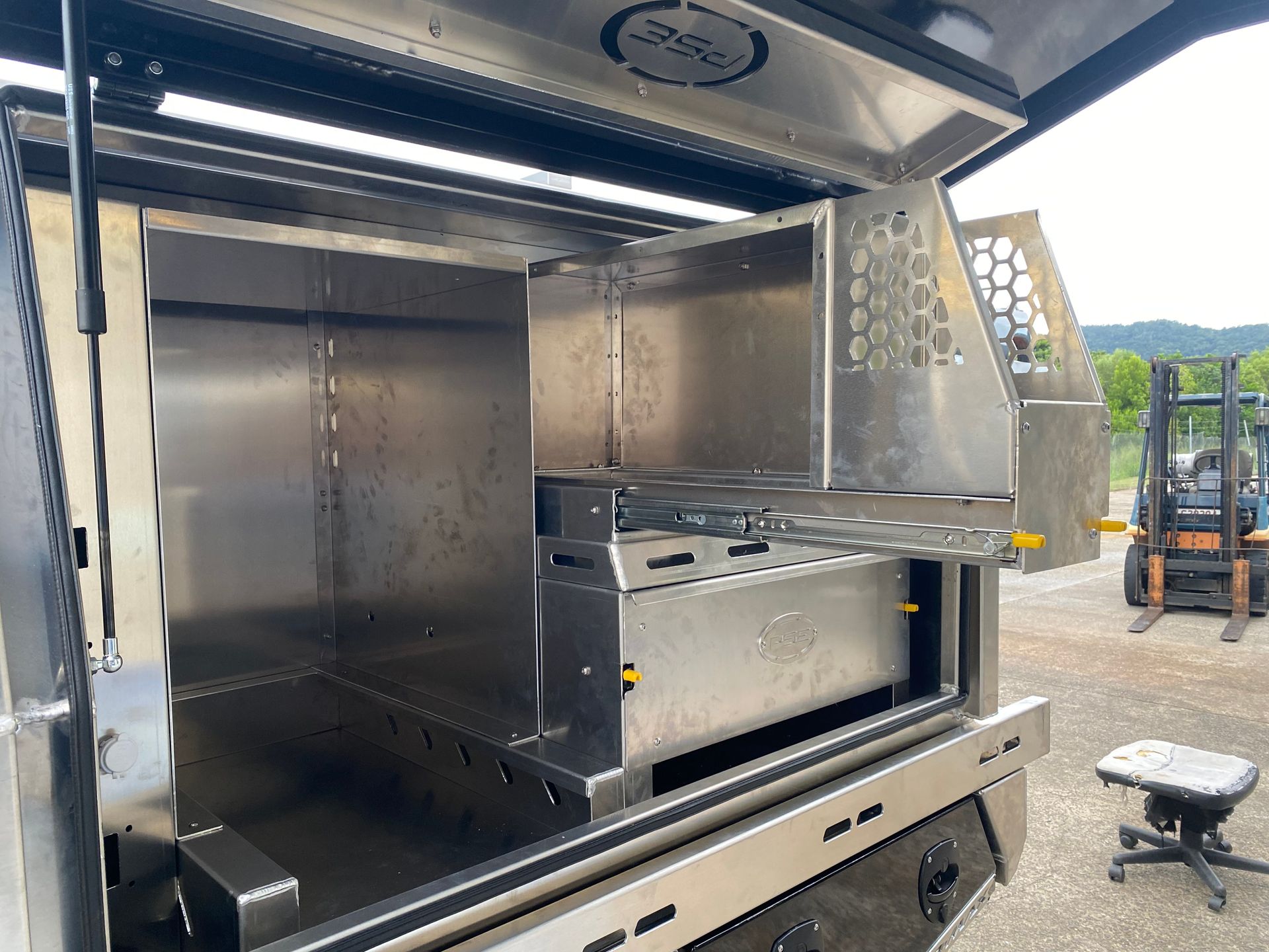 A stainless steel truck bed with the door open and a forklift in the background  — PSE Stainless Steel Fabrications in Manunda, QLD