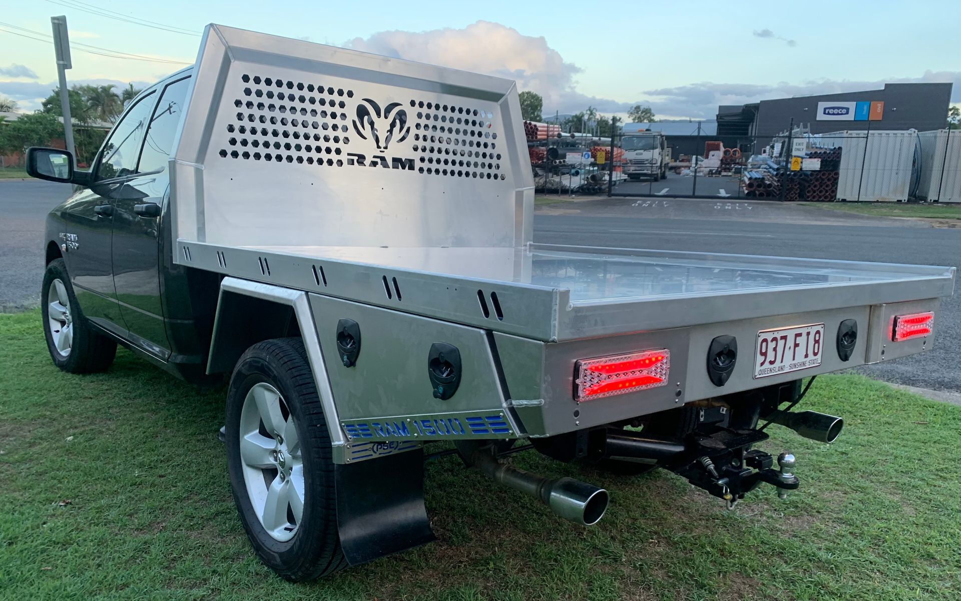 A black truck with a tray on the back is parked on the grass  — PSE Stainless Steel Fabrications in Manunda, QLD