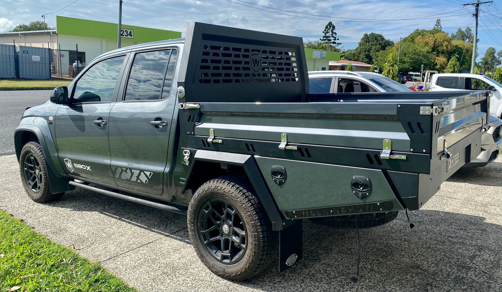 A truck with a cage on the back of it is parked in a parking lot  — PSE Stainless Steel Fabrications in Manunda, QLD