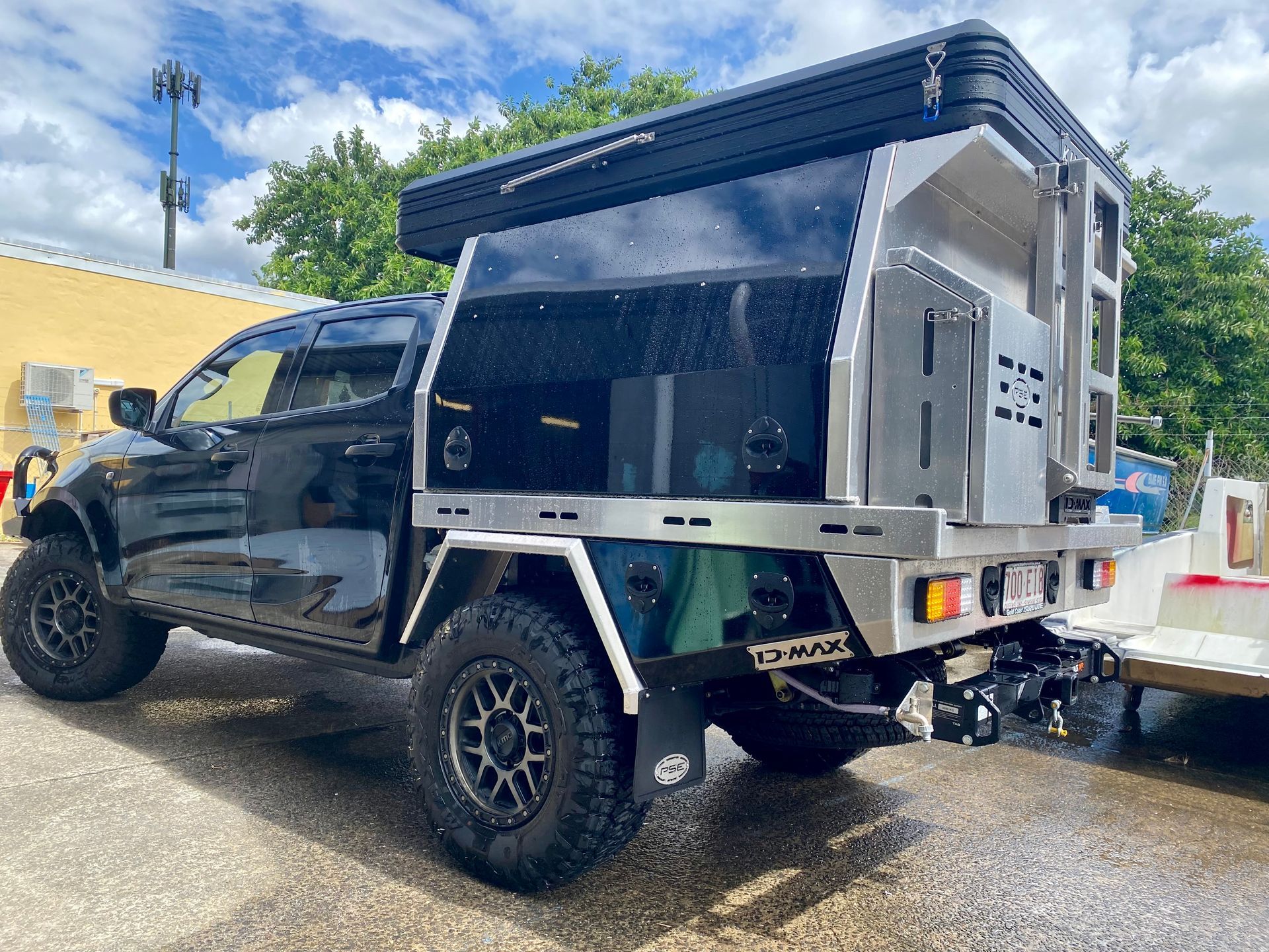 A black truck with a canopy on top of it is parked on the side of the road  — PSE Stainless Steel Fabrications in Manunda, QLD
