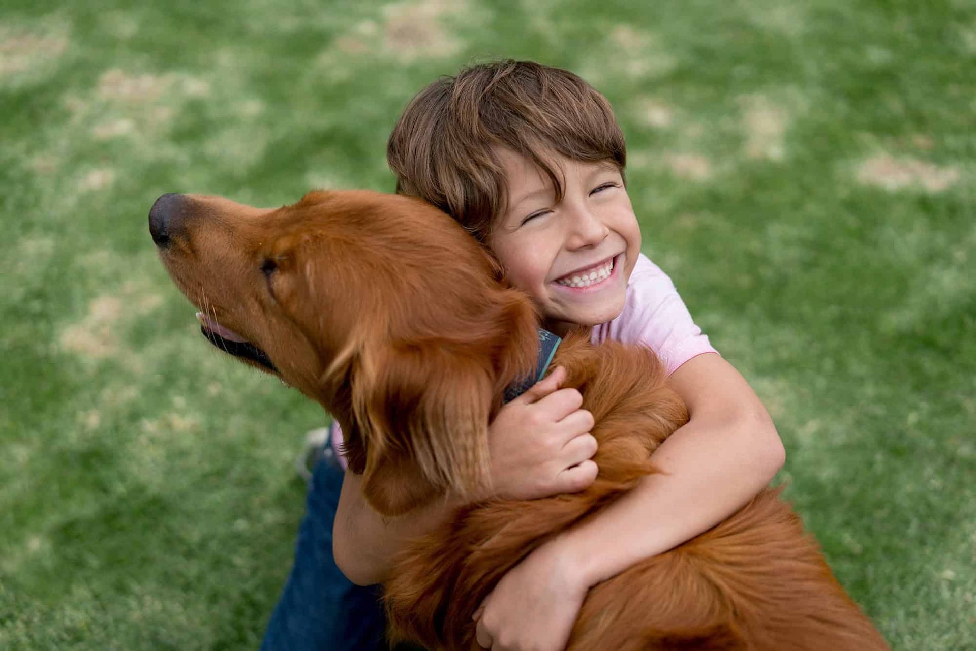 Young boy hugging dog