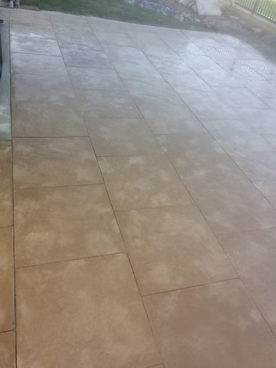 Tan stone patio with visible grout lines.