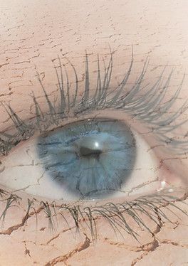 Blue eye with long lashes, overlaid with cracked, dry earth texture.