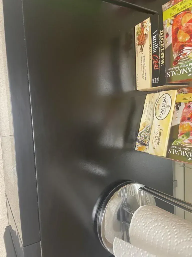 Black countertop with boxes and paper towels.