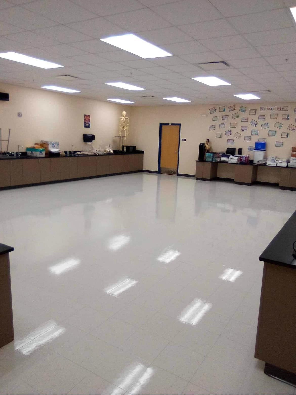 Empty science lab with shiny floor and lab stations against the walls.