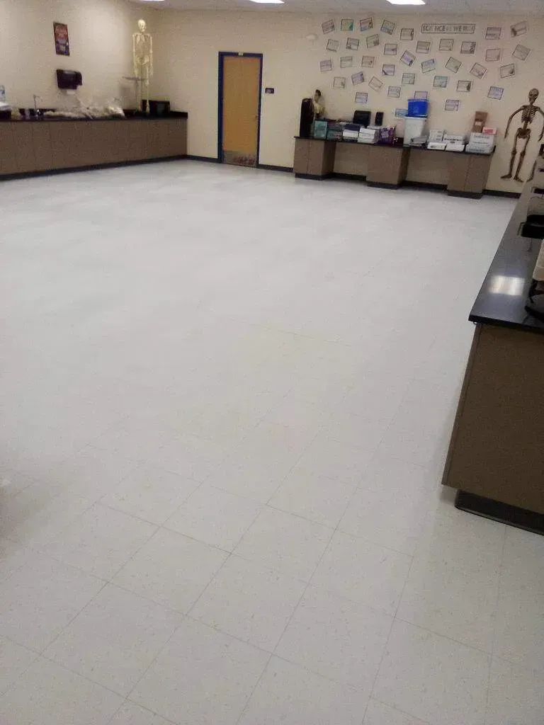 Empty science classroom with light-colored floors, counters, and skeletal displays.