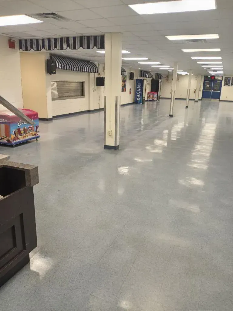 Empty cafeteria with shiny blue floor and serving area with striped awning.