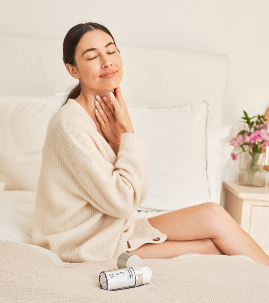 woman on bed with alastin skincare