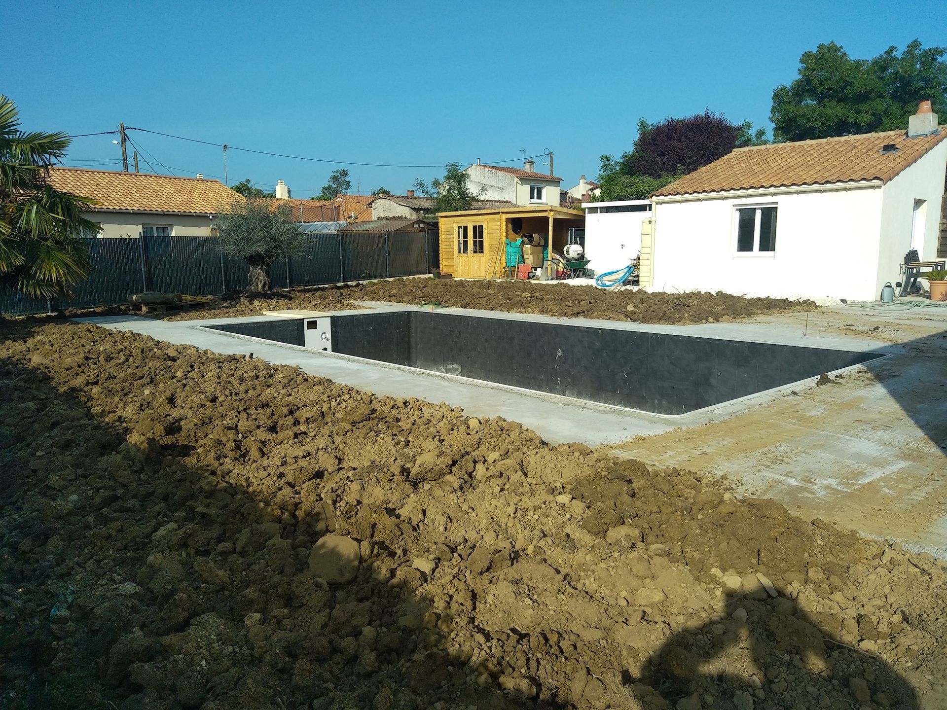 Une piscine est en cours de construction dans l'arrière-cour d'une maison