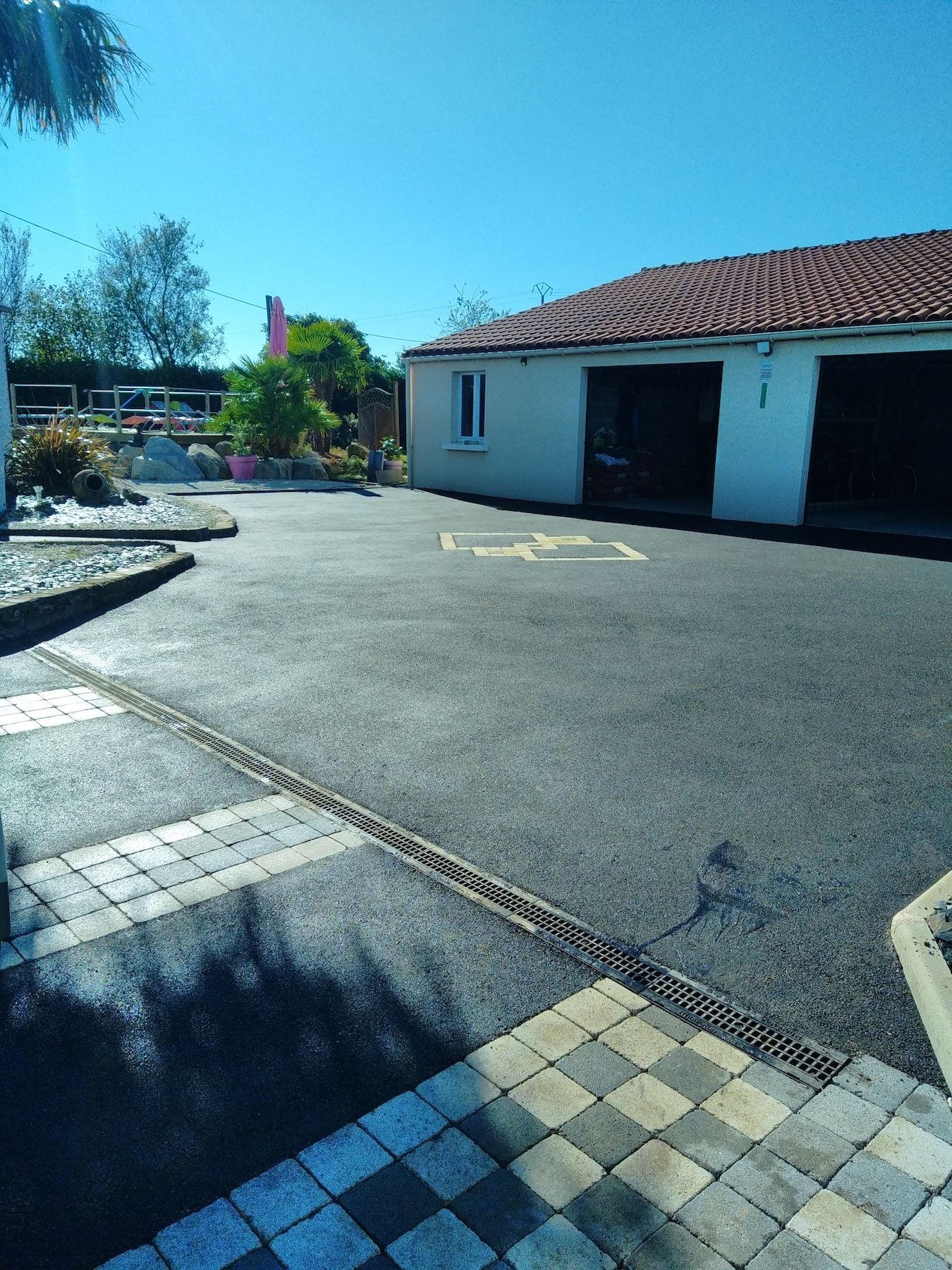 Une maison blanche au toit rouge est entourée d'un parking