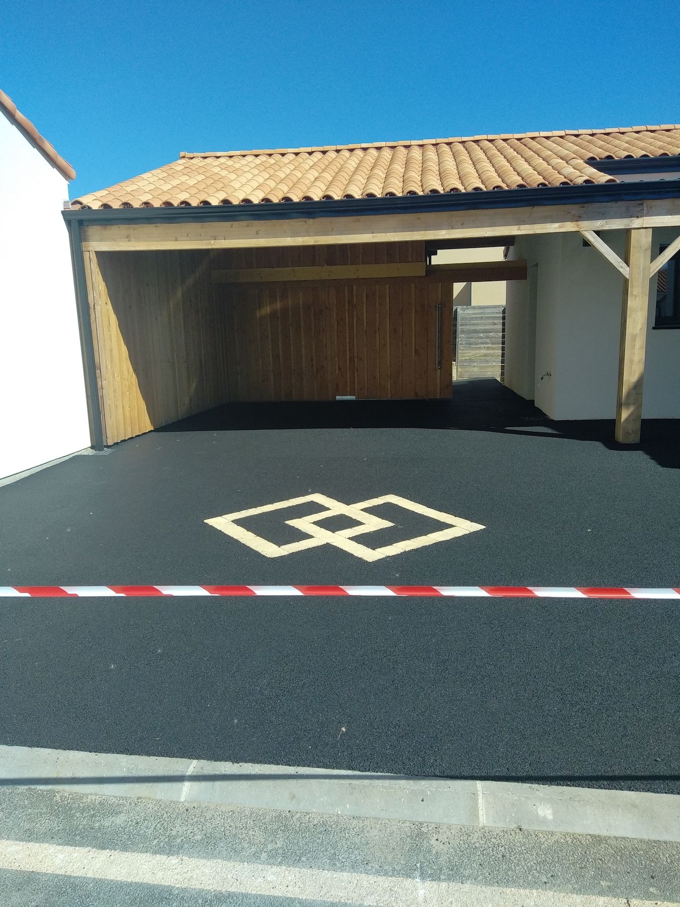 Un abri d'auto avec un motif en losange peint sur le sol