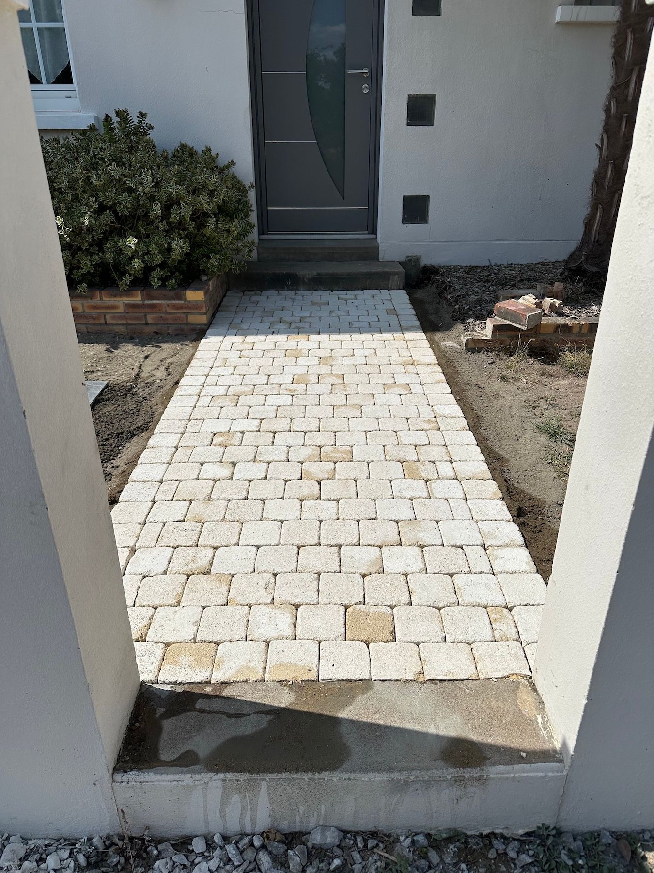 Une allée en briques menant à la porte d'entrée d'une maison.