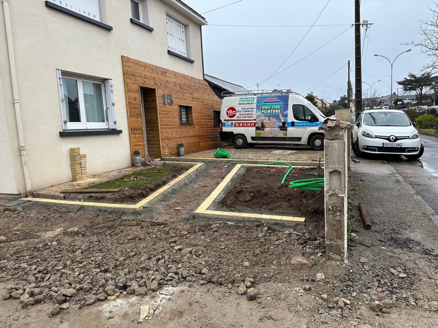 Une camionnette blanche est garée devant une maison.