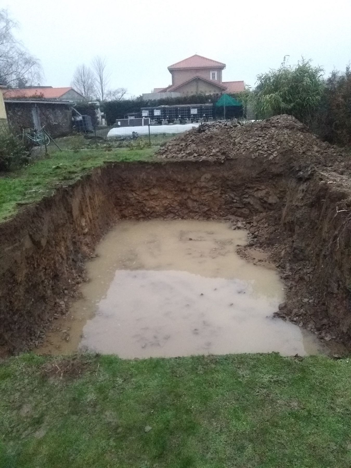 Une grande flaque d'eau se trouve au milieu d'un champ de terre.