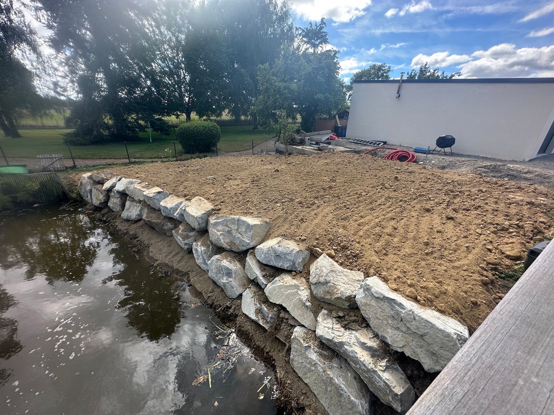 Un gros tas de rochers se trouve à côté d'un plan d'eau.