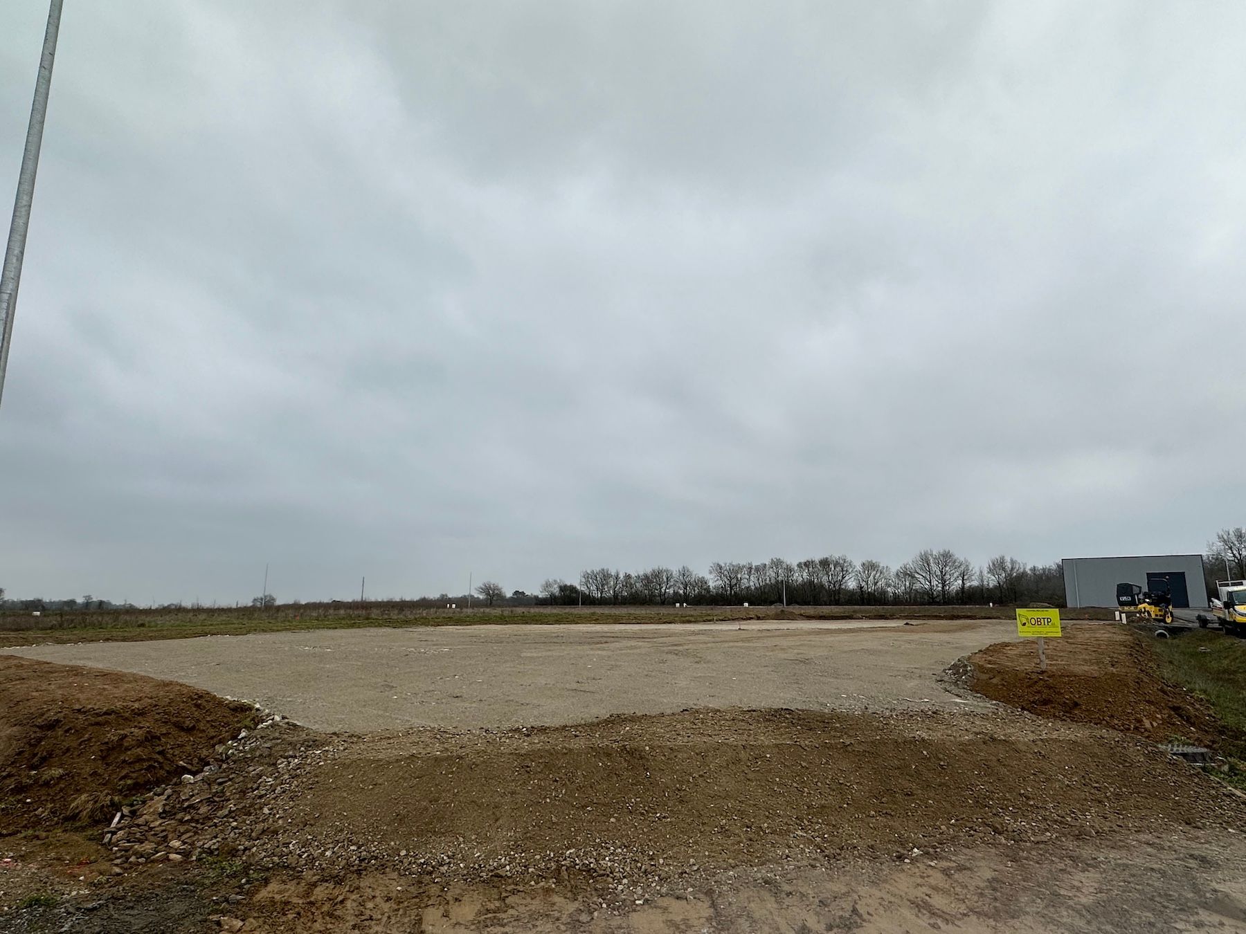 Un grand champ de terre avec un ciel nuageux en arrière-plan.