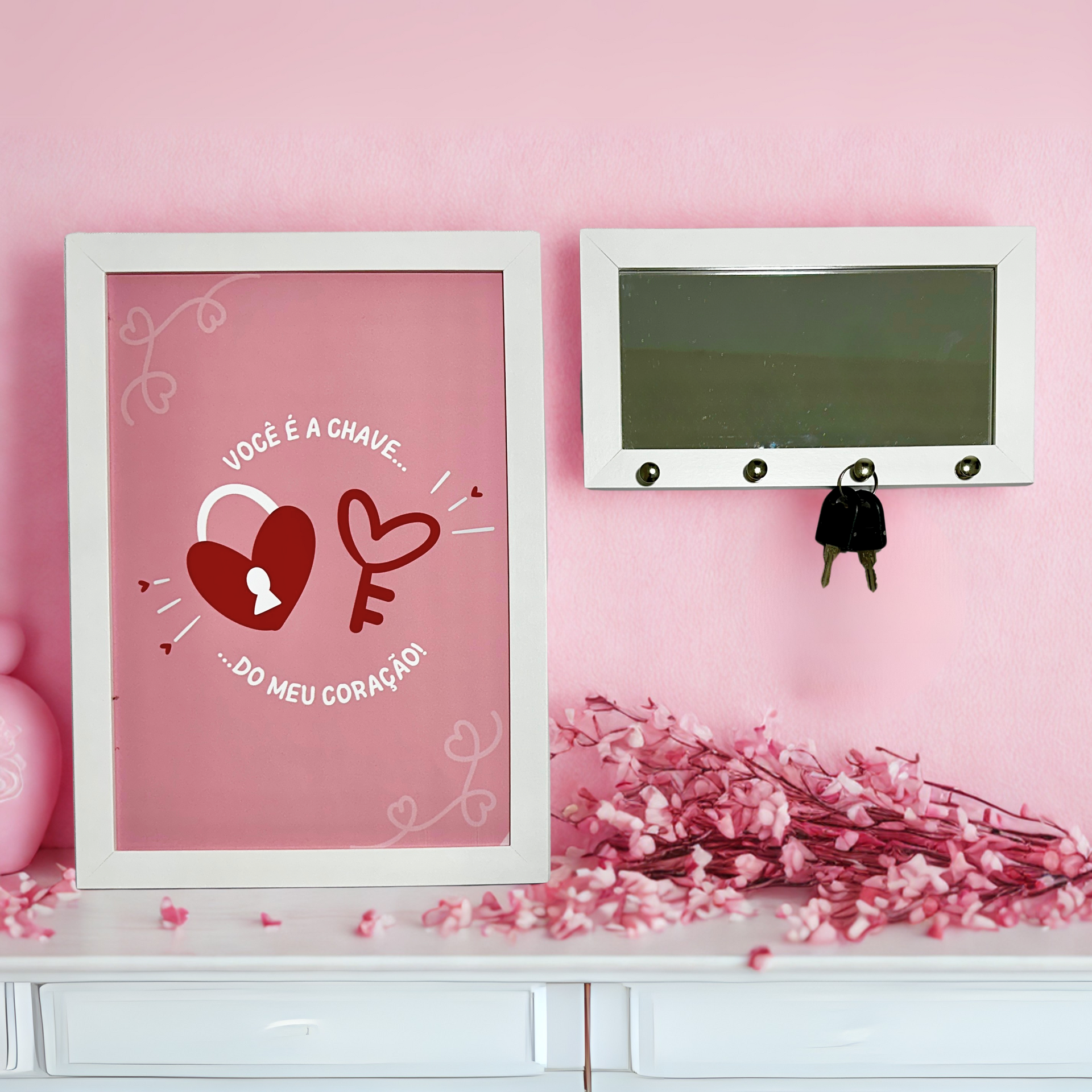 A pink wall with a picture and a key holder