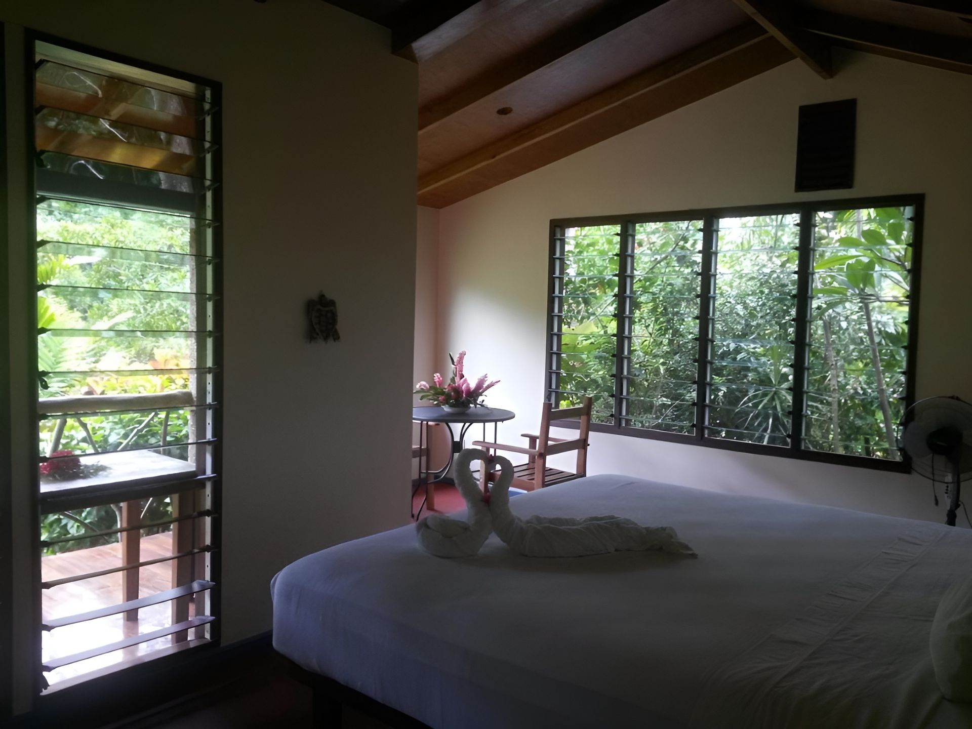 A bedroom with a large bed and lots of windows