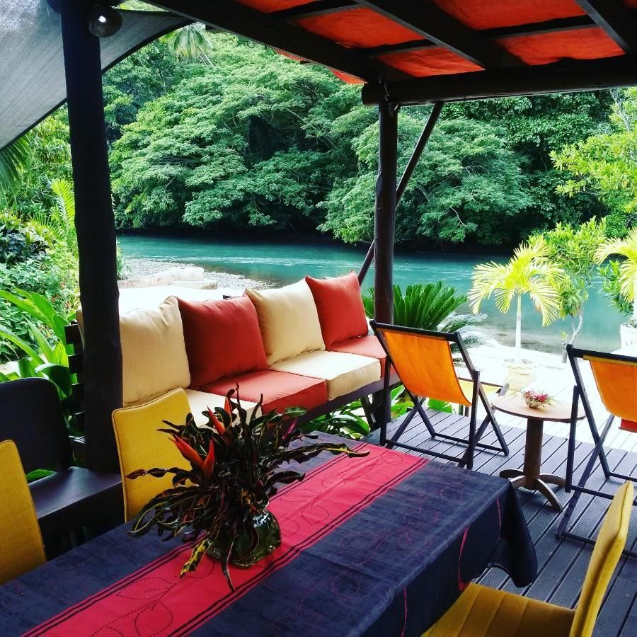A patio with a table and chairs overlooking a river