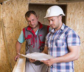 men inspecting building plans
